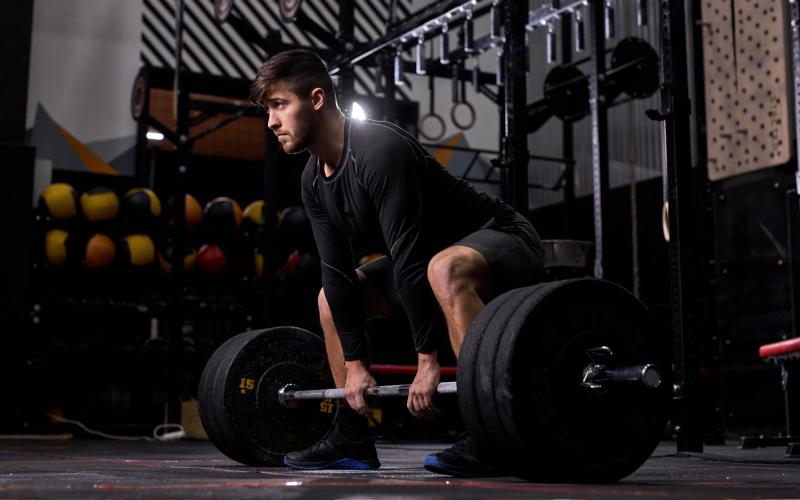 Strong man doing heavy deadlifts in the gym.